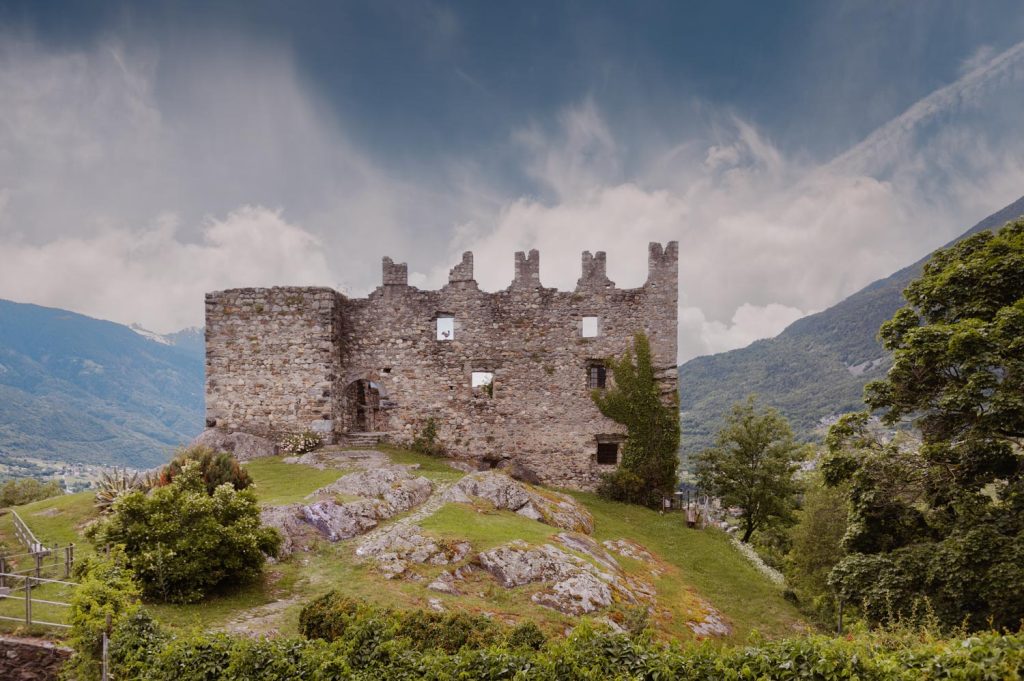 Castello di Mancapane in Valtellina con vista sulle montagne e prato roccioso, location ideale per servizi fotografici di matrimonio